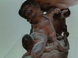 a statue of a child on a boat in a glass case