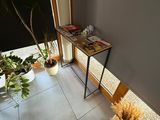 une petite table sur laquelle se trouve une plante, dans une pièce