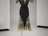 une robe noire et blanche posée sur un mannequin dans une pièce