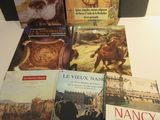 Plusieurs livres sont empilés sur une table devant une mallette noire