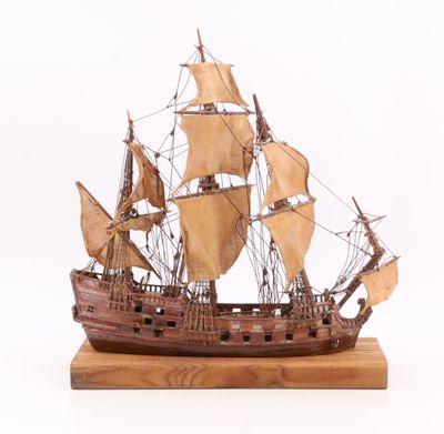 une maquette en bois d'un voilier posée sur un socle