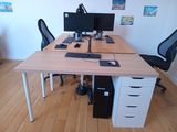 a computer desk with two monitors and a keyboard on it