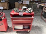 un chariot à outils rouge sur lequel se trouvent de nombreux outils