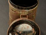 a small metal container with a lid sitting on a table