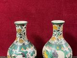 deux vases posés sur une table, sur fond rouge