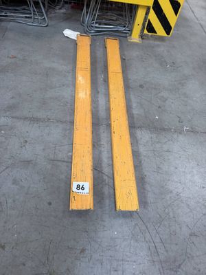 two pieces of yellow tape on the floor next to a pile of chairs