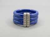 a close up of a blue ring with two rows of diamonds