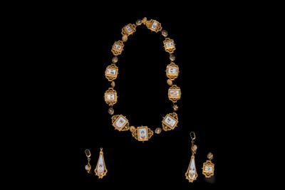 un gros plan d'un collier et de boucles d'oreilles sur fond noir
