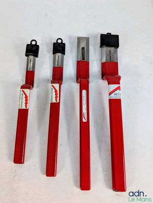 trois outils rouges posés sur une surface blanche