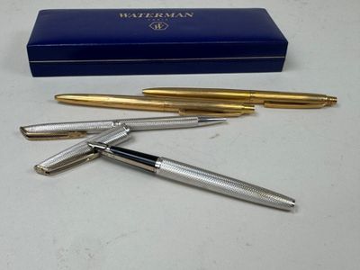 two fountain pens and a box on a table
