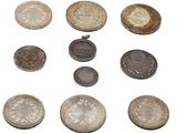 plusieurs types de pièces de monnaie sont présentés sur une surface blanche
