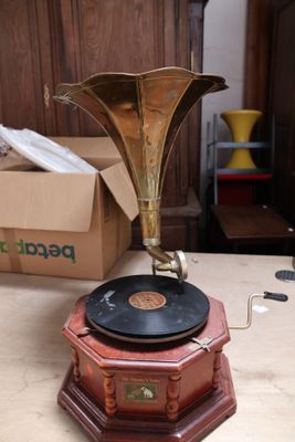 une table en bois sur laquelle est posé un disque, avec un tourne-disque posé dessus
