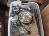 a basket full of glass items sitting on the floor