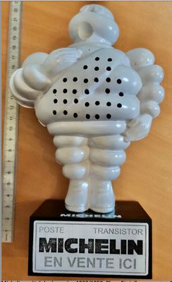 une statue blanche représentant un homme tenant un micro