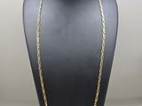 a gold chain necklace on a mannequin display
