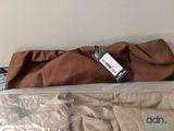 a bed that has a brown blanket on it