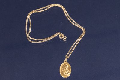 un collier plaqué or avec une pièce suspendue à une chaîne