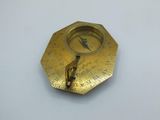a gold plate with a compass on it on a white surface
