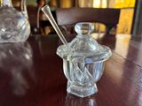 a glass jar with a spoon sitting on a wooden table