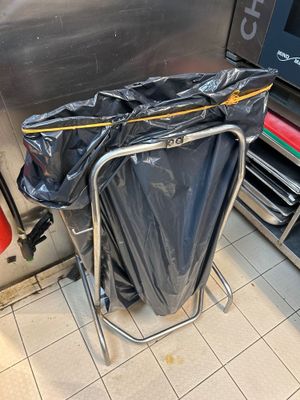 une poubelle au milieu d'une cuisine, avec un sac poubelle posé dessus