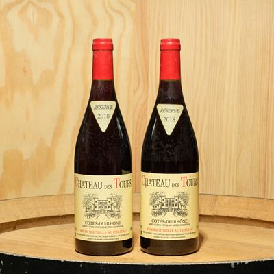 two bottles of wine sitting on top of a barrel