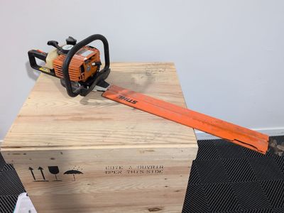 an orange chainsaw sitting on top of a wooden box