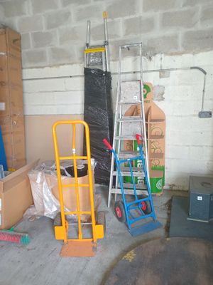 many boxes and ladders in a garage with boxes on the floor