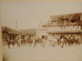 a old photo of a horse drawn carriage in front of a building
