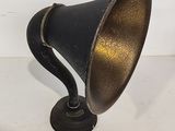 an old fashioned black and gold lamp on a white surface