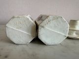 two white hexagons sitting on a marble table