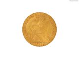gros plan d'une pièce d'or sur une surface blanche
