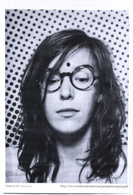 black and white photograph of a woman with glasses and a polka dot background