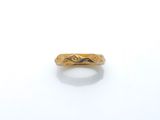 gros plan d'une bague en or sur une surface blanche