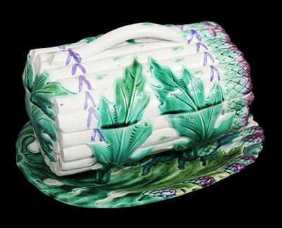 une boîte en céramique verte et blanche ornée de fleurs violettes