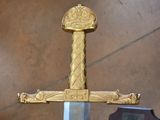 a gold sword with a crown on top of it