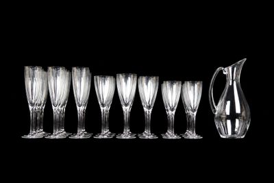 several empty wine glasses and a pitcher on a black background