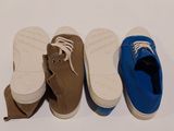 three pairs of shoes are lined up in a row on a white surface