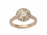 une bague de fiançailles en or jaune sertie d'un diamant ovale de couleur champagne, entouré de diamants blancs
