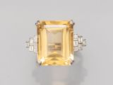 une photo d'une bague sertie d'un saphir jaune et de diamants