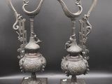 paire de vases anciens en bronze chinois, ornés de poignées en forme de dragon, posés sur des socles