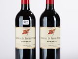 deux bouteilles de vin rouge posées l'une à côté de l'autre sur une surface blanche