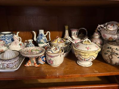 une étagère en bois sur laquelle sont disposées de nombreuses théières de styles variés