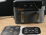 a black air fryer sitting on a wooden table