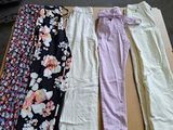 de nombreux pantalons de différentes couleurs posés sur une table dans une pièce