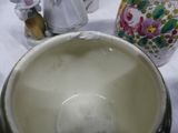 a white bowl sitting on top of a table next to a vase