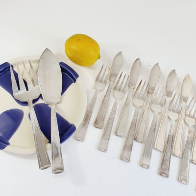 a plate with a bunch of silverware on it next to a lemon
