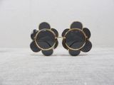 pair of black and gold flower shaped sunglasses on a white surface
