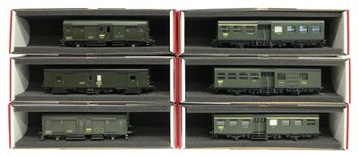six wagons verts sont placés dans une boîte posée sur une surface blanche