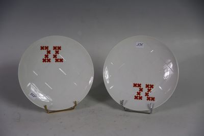une paire d'assiettes blanches ornées de lettres rouges brodées au point de croix