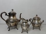 trois pièces en argent pour le thé et le café sur une table